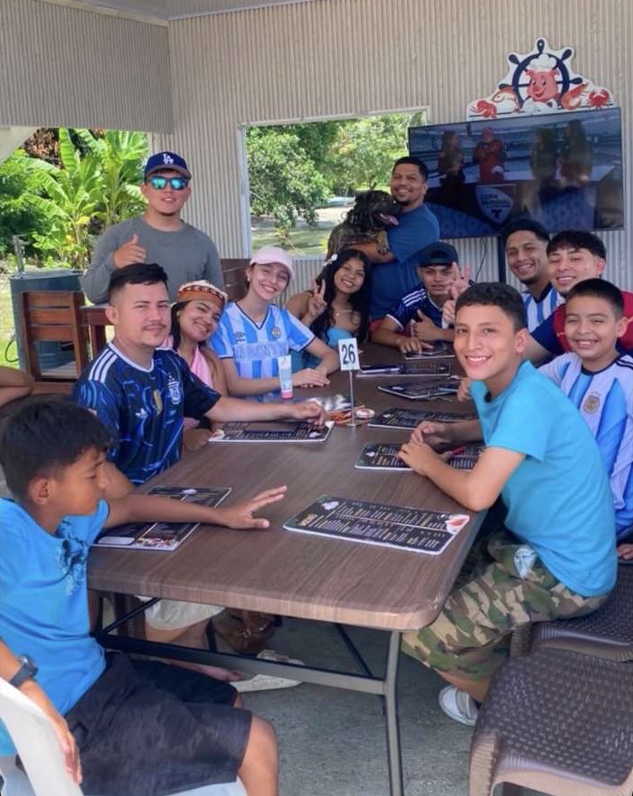 Grupo grande celebrando en una mesa larga de El Lechón Playero